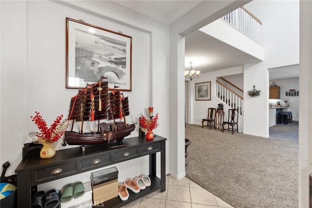 hallway featuring ornamental molding, light colored carpet, and a notable chandelier