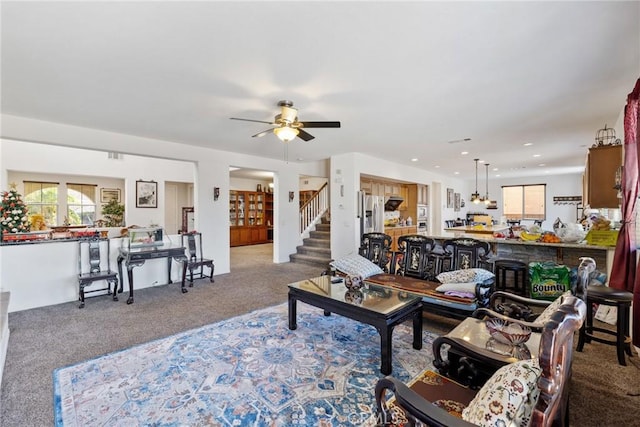 carpeted living room with ceiling fan