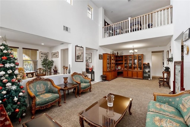 carpeted living room featuring a high ceiling and an inviting chandelier