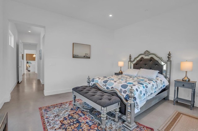 bedroom with concrete floors, baseboards, and recessed lighting