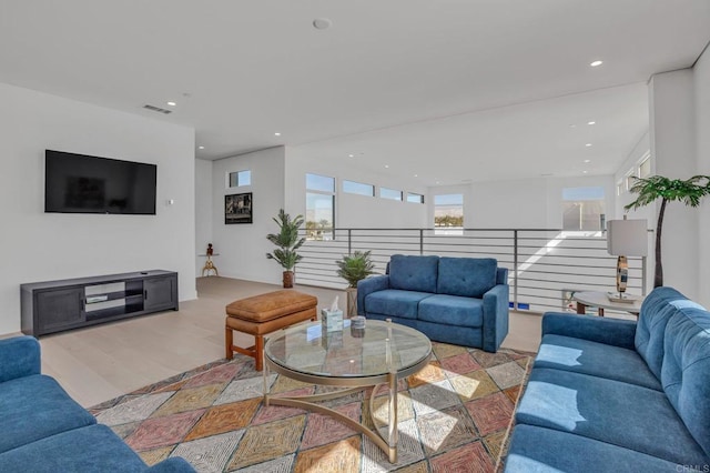 living room with light wood finished floors, visible vents, and recessed lighting