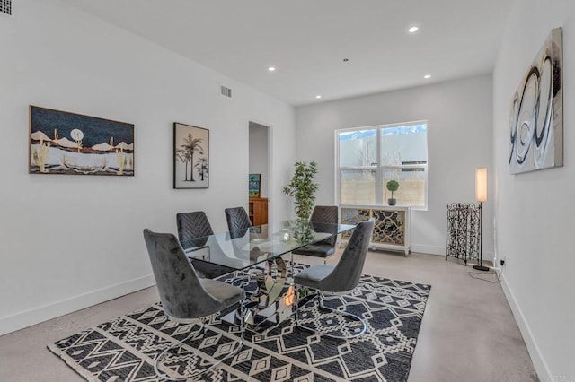 dining space featuring concrete floors, baseboards, and recessed lighting