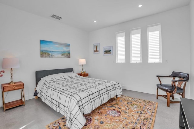 bedroom featuring finished concrete flooring and recessed lighting