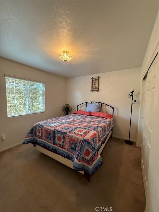 bedroom with a closet and dark colored carpet