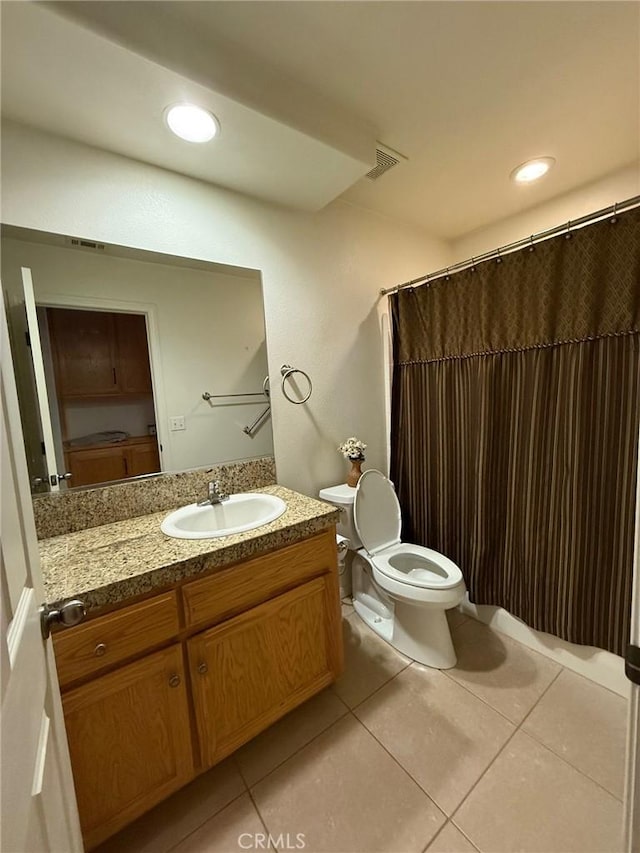 bathroom with tile patterned flooring, vanity, and toilet