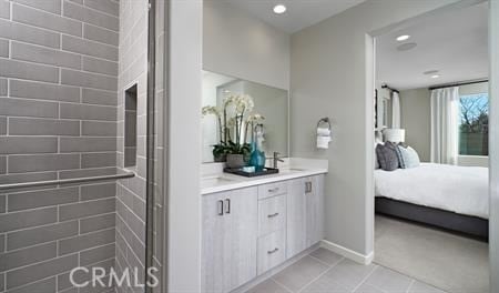 bathroom with tile patterned flooring, vanity, and a shower