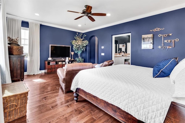 bedroom with hardwood / wood-style floors, connected bathroom, ceiling fan, and ornamental molding