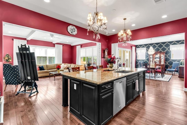 kitchen featuring pendant lighting, an island with sink, stainless steel dishwasher, and hardwood / wood-style flooring