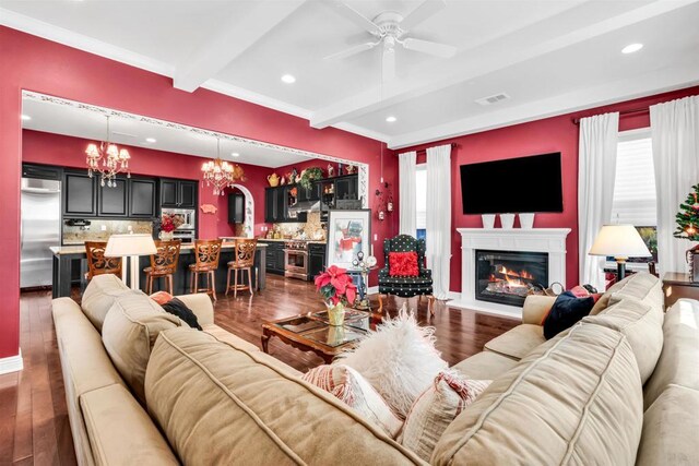 living room featuring beam ceiling, ceiling fan with notable chandelier, and dark hardwood / wood-style floors