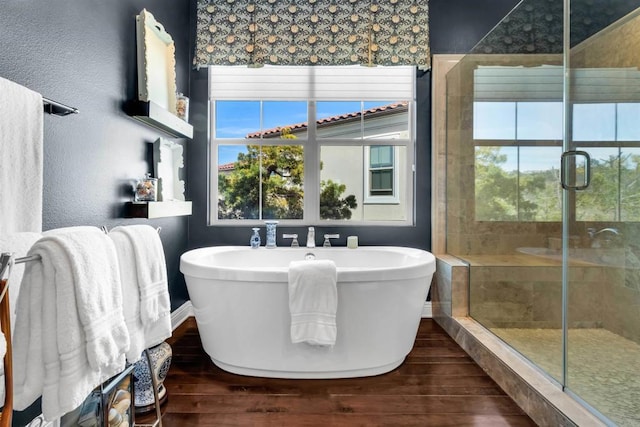 bathroom featuring hardwood / wood-style flooring and plus walk in shower