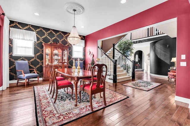 dining space with hardwood / wood-style floors and a notable chandelier