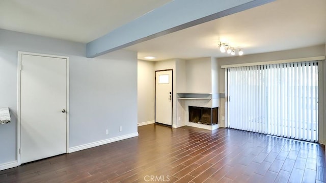 unfurnished living room with beamed ceiling, a multi sided fireplace, and dark wood-type flooring