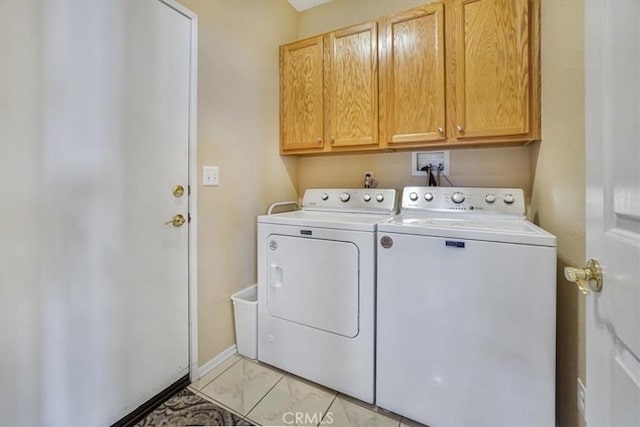 clothes washing area featuring cabinets and washing machine and clothes dryer