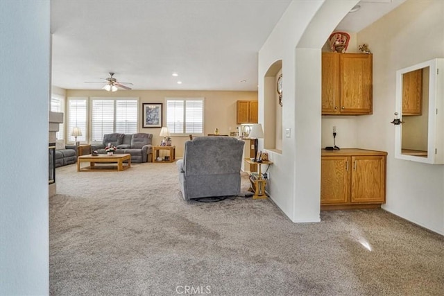 carpeted living room featuring ceiling fan