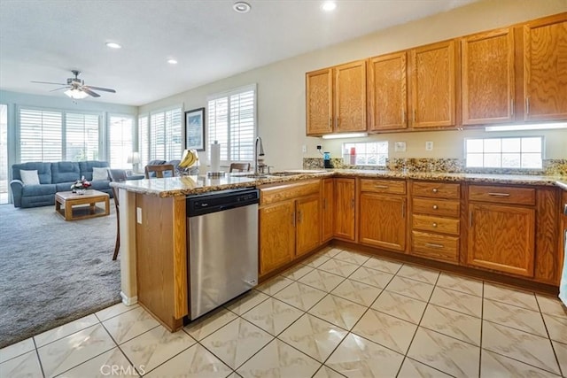 kitchen featuring light stone countertops, ceiling fan, stainless steel dishwasher, kitchen peninsula, and light carpet