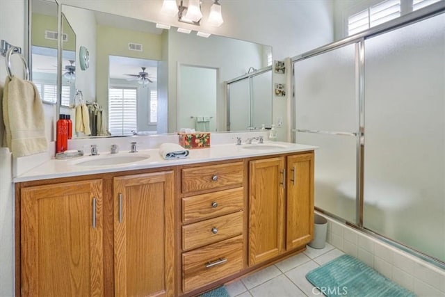 bathroom with ceiling fan, tile patterned flooring, vanity, and walk in shower