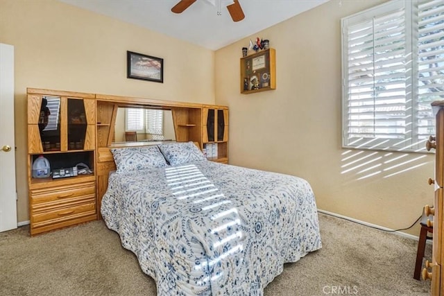 carpeted bedroom featuring ceiling fan and multiple windows