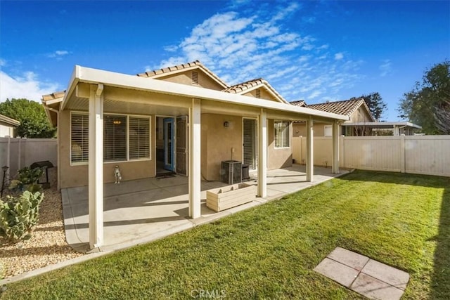 rear view of house featuring a lawn, central AC unit, and a patio area