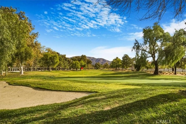 surrounding community with a mountain view and a yard