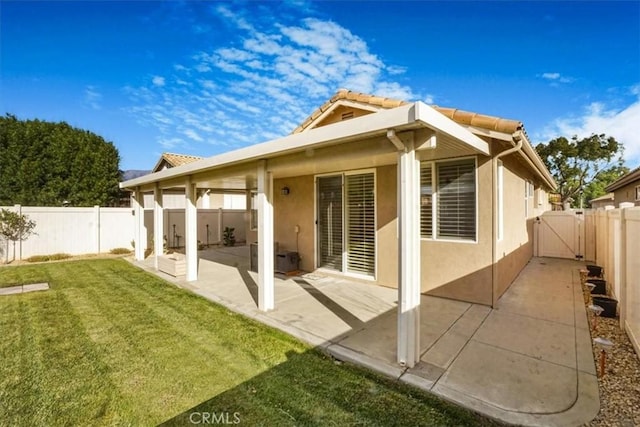 rear view of house with a yard and a patio