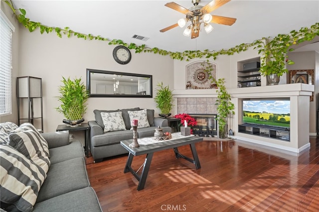 living room with a fireplace, ceiling fan, and dark hardwood / wood-style flooring