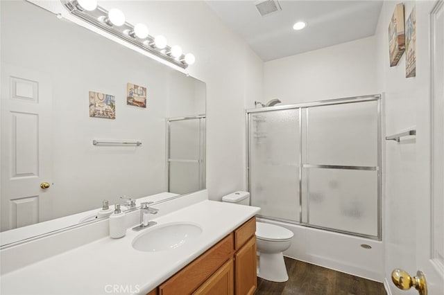 full bathroom with toilet, combined bath / shower with glass door, wood-type flooring, and vanity