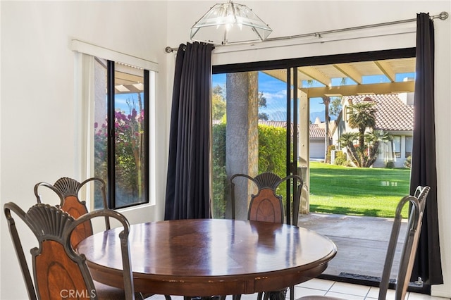 tiled dining space with a chandelier and a healthy amount of sunlight