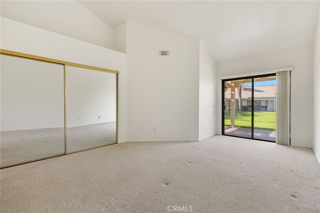 carpeted spare room featuring lofted ceiling