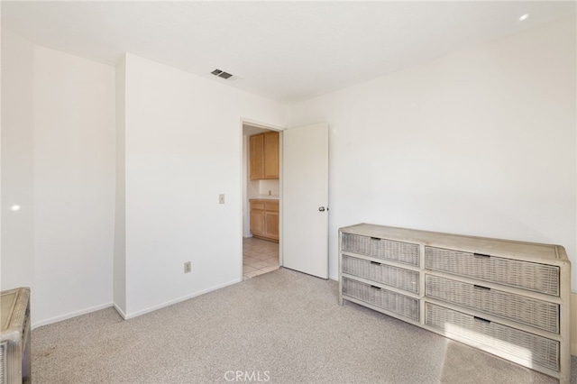 interior space with visible vents, light colored carpet, and baseboards