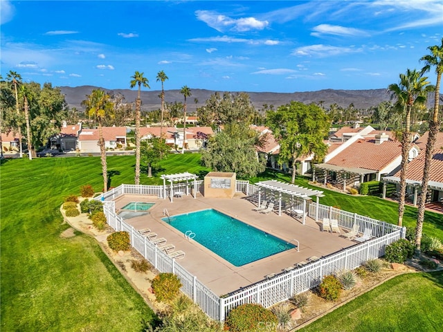 community pool with a mountain view, a pergola, fence, and a patio area