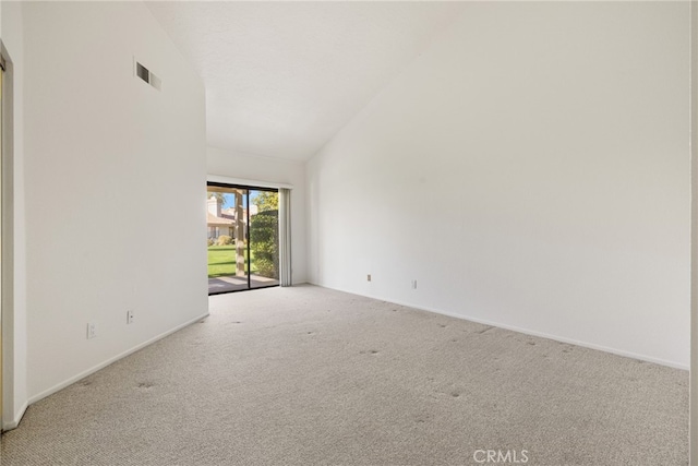 carpeted empty room with high vaulted ceiling