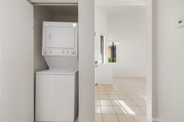 laundry room with stacked washer / drying machine and light tile patterned floors