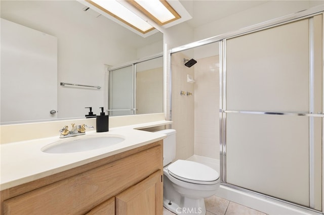 bathroom featuring tile patterned flooring, vanity, toilet, and a shower with shower door