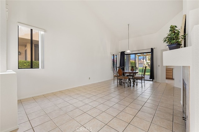 tiled dining room with high vaulted ceiling and an inviting chandelier