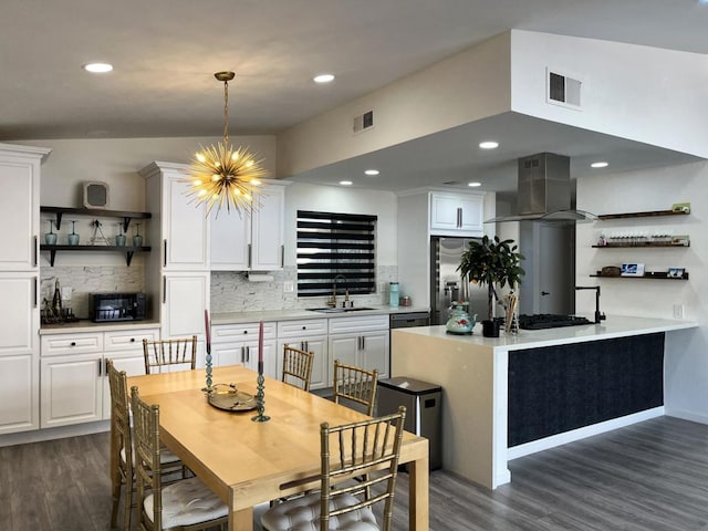 dining space with dark hardwood / wood-style flooring, sink, and an inviting chandelier