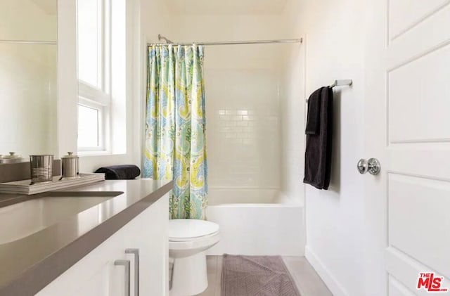 bathroom with shower / bath combination with curtain and toilet