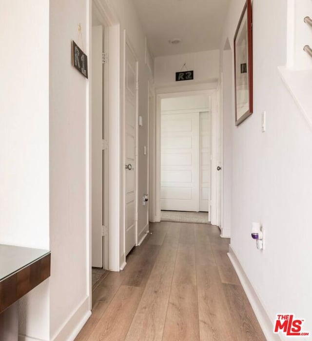 corridor with light wood-type flooring