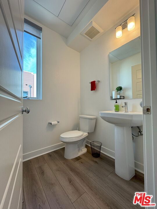 bathroom featuring wood-type flooring, toilet, and sink