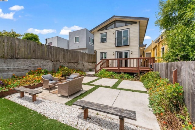 rear view of property with an outdoor living space, a patio, and a wooden deck