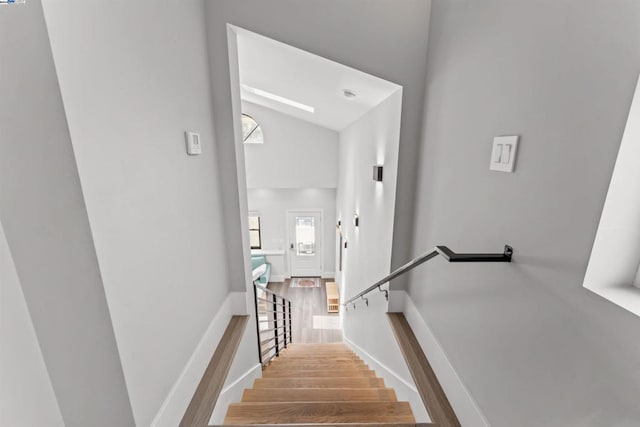 staircase featuring hardwood / wood-style floors and vaulted ceiling