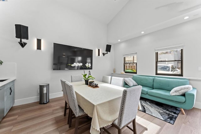 dining space with lofted ceiling and light wood-type flooring