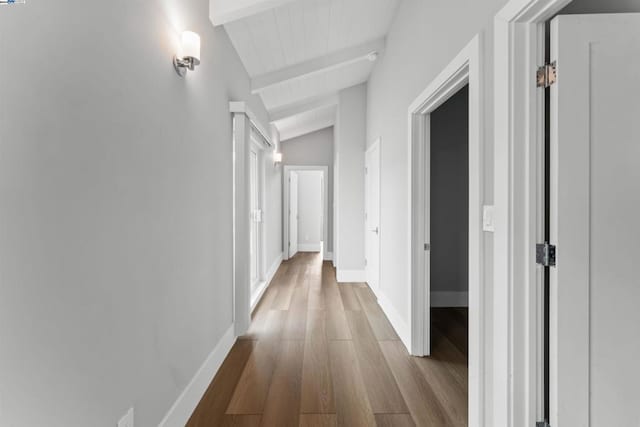 hallway featuring lofted ceiling with beams and light hardwood / wood-style floors