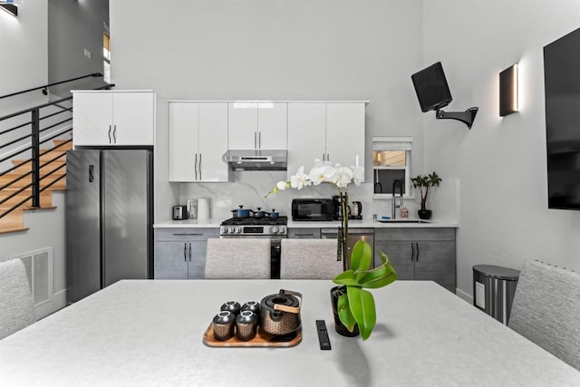 kitchen featuring decorative backsplash, sink, white cabinets, and stainless steel appliances