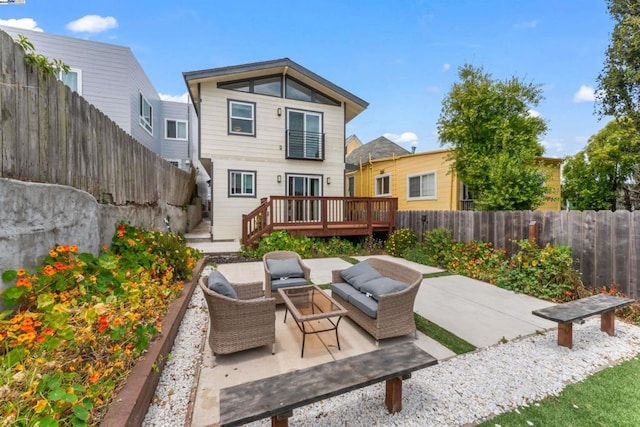 back of property with an outdoor hangout area, a deck, and a patio