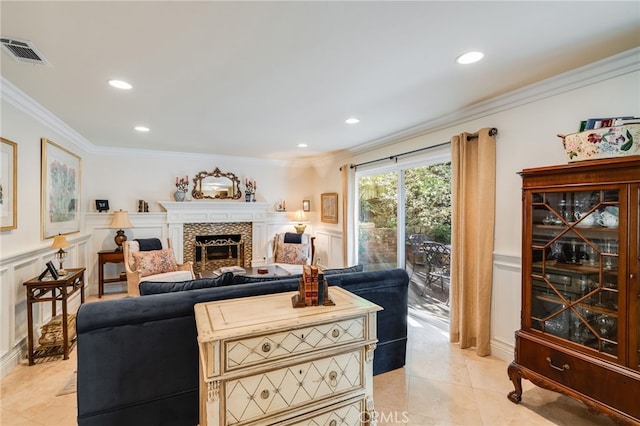 living room featuring crown molding, a tiled fireplace, and light tile patterned floors