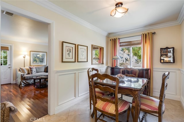 tiled dining area featuring crown molding