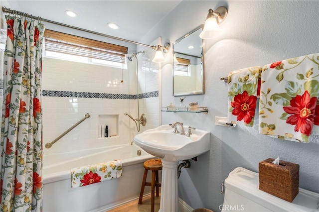 full bathroom with sink, shower / bath combination with curtain, and toilet