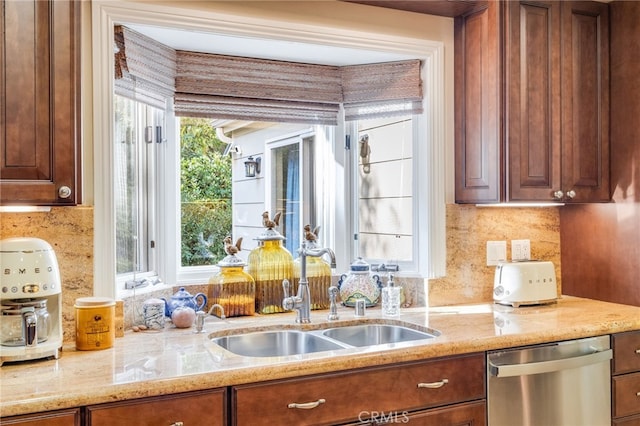 kitchen with tasteful backsplash, sink, stainless steel dishwasher, and light stone countertops