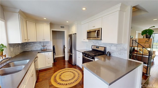 kitchen with white cabinets, sink, stainless steel appliances, and dark wood-type flooring