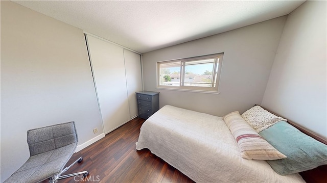 bedroom featuring a textured ceiling and dark hardwood / wood-style flooring